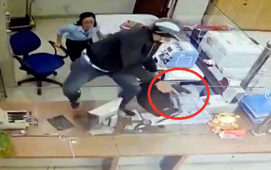 Tên cướp dùng vật giống súng uy hiếp nhân viên ngân hàng và lấy đi khoảng 3 tỉ đồng.