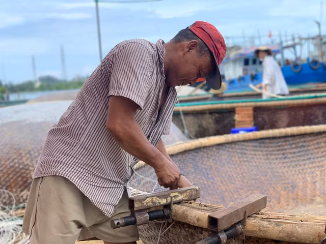 Sau chuyến biển dài ngày, những người đàn ông xóm Cù Lao lại sửa chữa các dụng cụ hành nghề. Ảnh: THANH QUÂN