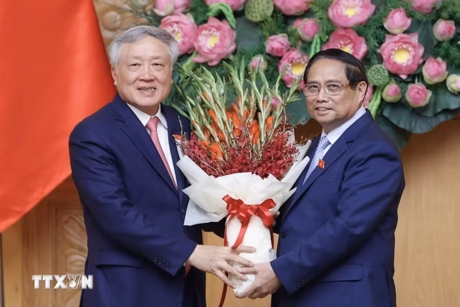 Thủ tướng Chính phủ Phạm Minh Chính tặng hoa chúc mừng tân Phó Thủ tướng Chính phủ Nguyễn Hòa Bình. (Ảnh: Dương Giang.TTXVN)