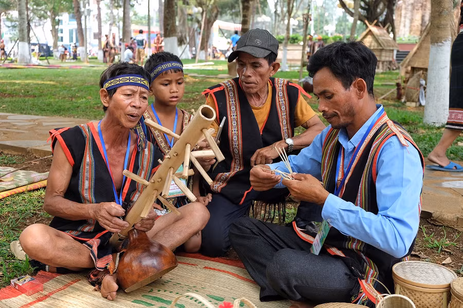 Nghệ nhân Byơh hát dân ca Bahnar cùng chiếc đàn goong do ông chế tác. Ảnh: Hoàng Ngọc