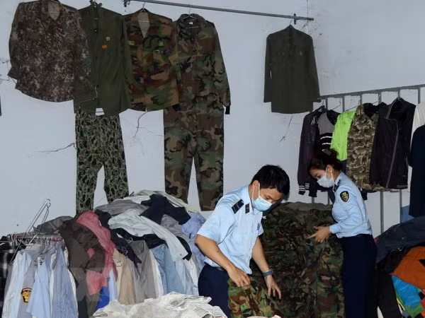 Lực lượng chức năng kiểm tra hàng hóa là quần áo rằn ri tại số 183 đường Hùng Vương, thị trấn Đăk Hà, huyện Đăk Hà, tỉnh Kon Tum. (Ảnh: Cao Nguyên/TTXVN)
