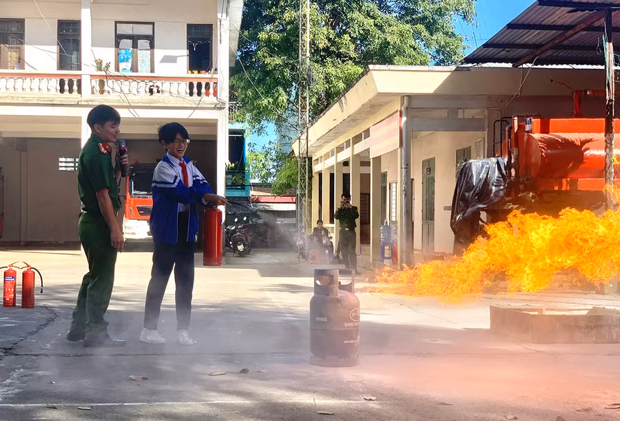 Học sinh Trường THCS Trần Phú (phường Trà Bá, TP. Pleiku) thực hành sử dụng bình chữa cháy xách tay để dập tắt đám cháy do rò rỉ khí gas. Ảnh: R.H