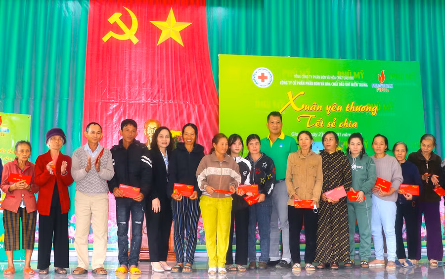 Bà Lê Thị Hồng Minh (thứ 5 từ trái sang)-Phó Chủ tịch UBND thị xã An Khê trao quà do Công ty cổ phần Phân bón và hóa chất dầu khí miền Trung tài trợ cho hộ nghèo. Ảnh: N.M
