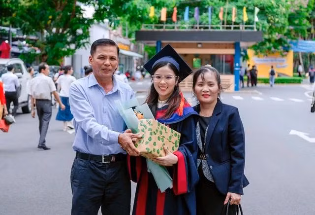 Ngân và ba mẹ trong buổi lễ tốt nghiệp. Ảnh NVCC