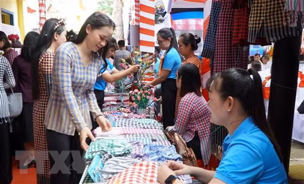Khách hàng chọn mua sản phẩm khăn choàng Long Khánh A (Hồng Ngự, Đồng Tháp). (Ảnh: Nhựt An/TTXVN)