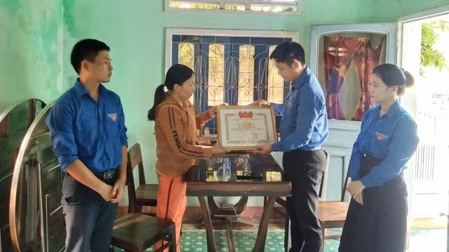 Đại diện Tỉnh đoàn Bình Định trao bằng khen truy tặng Thiệp cho gia đình nhận. Ảnh: SONG THIÊN