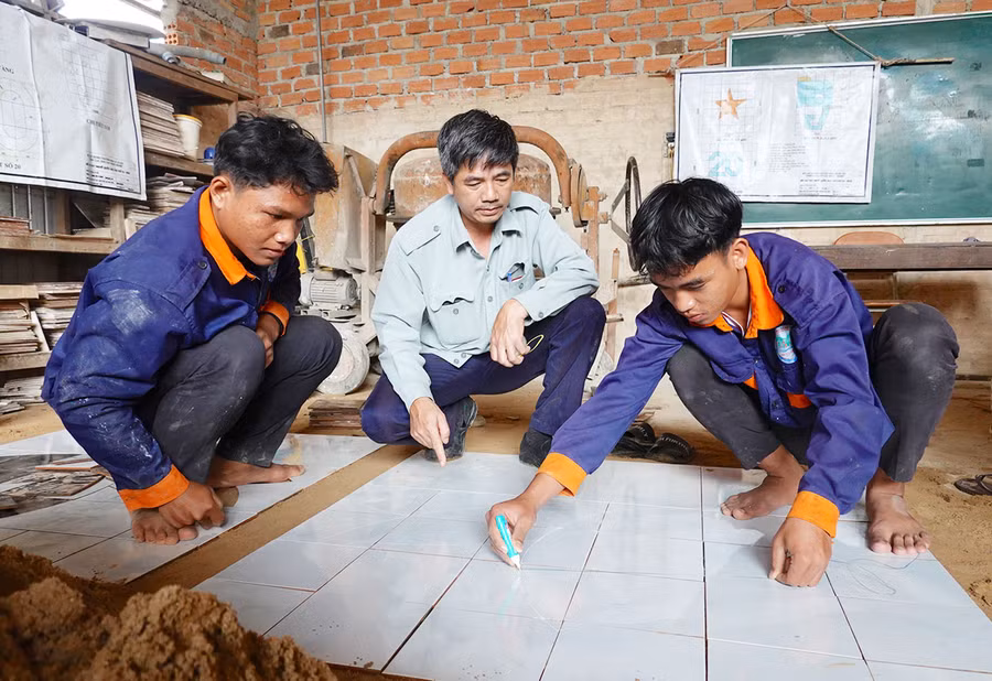 Em Siu Dũng (bìa trái, làng Đut, xã Ia Lâu, huyện Chư Prông) trong một buổi thực hành kỹ thuật cắt gạch. Ảnh: M.T