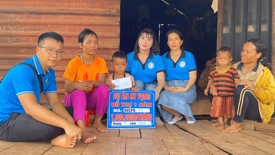 Anh Nguyễn Đắc Kiên Bình (bìa trái) cùng các thành viên dự án Hy vọng trao tiền hỗ trợ cho thiếu nhi khó khăn. Ảnh: Phan Lài