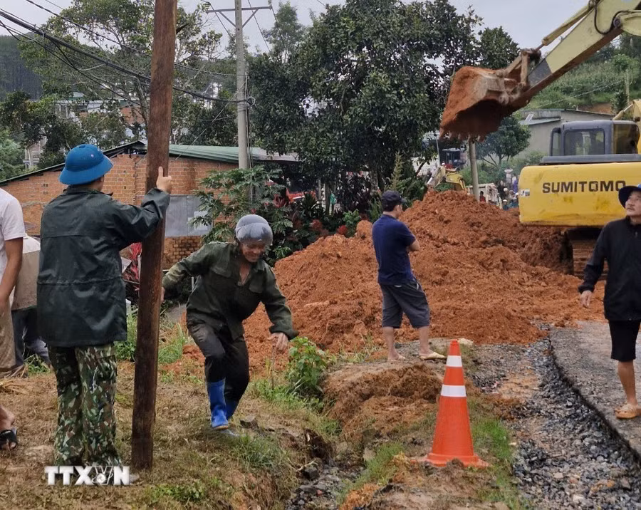 Lực lượng chức năng cùng thiết bị cơ giới triển khai công tác cứu hộ, giải tỏa hiện trường. (Ảnh: TTXVN phát)
