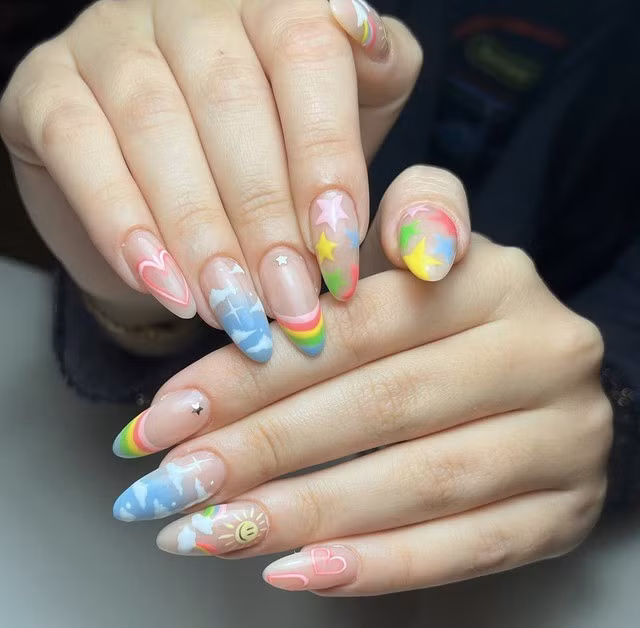 Không chỉ có trang phục hay các phong cách trang điểm mà nhờ các mẫu nail, bạn cũng có thể trẻ trung hơn đến vài tuổi. Nếu không tin, hãy thử trải nghiệm với bộ nail vẽ hình đám mây, cầu vồng, bầu trời và ngôi sao nhiều màu này.