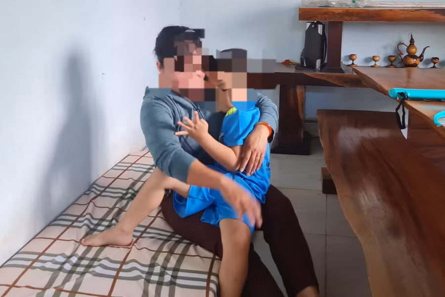 Bé trai 4 tuổi bị bỏ rơi đang được một cán bộ xã Hòa Xuân chăm sóc.
