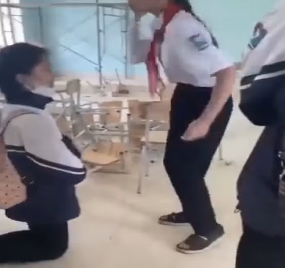 Nữ sinh bị đánh phải quỳ dưới đất và không dám phản kháng được đưa lên mạng xã hội. Ảnh cắt từ clip