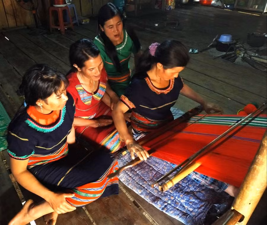 Chị Y Hlạng hướng dẫn các chị em làng Pu Tá dệt vải góp phần gìn giữ bản sắc văn hóa dân tộc Xơ Đăng. Ảnh: PN