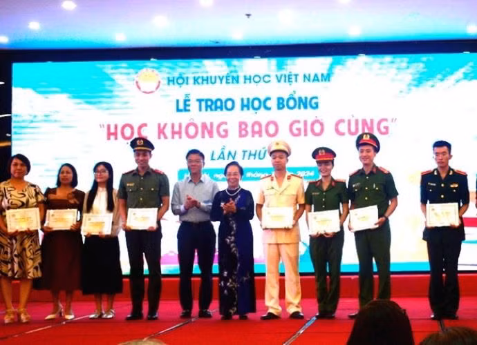 Phó thủ tướng Lê Thành Long và Giáo sư-Tiến sỹ Nguyễn Thị Doan trao học bổng "Học không bao giờ cùng." (Nguồn: Báo Quân đội Nhân dân)