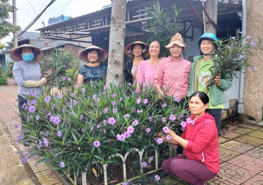 Chi hội Phụ nữ tổ 4 chăm sóc con đường hoa tại khu dân cư. Ảnh: R'Ô HOK
