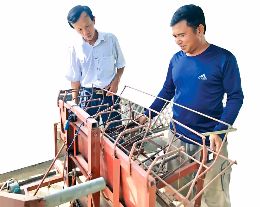 Ông Phạm Văn Bình (bìa phải) giới thiệu với ông Nguyễn Đình Nhung-Chủ tịch Hội Nông dân huyện Krông Pa máy cắt hom mì do mình sáng chế. Ảnh: L.N