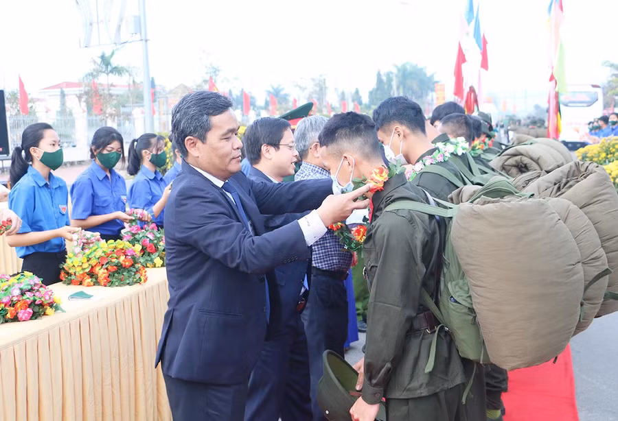 Bí thư Tỉnh ủy Hồ Văn Niên tặng hoa, động viên thanh niên lên đường nhập ngũ. Ảnh: Quang Tấn