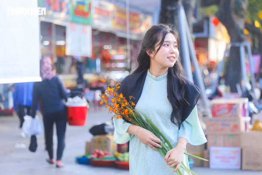 Để cho ra bộ ảnh đúng "vị" tết xưa, ngoài áo dài, các bạn trẻ còn đầu tư thêm các phụ kiện như hoa tươi, túi xách. Ảnh: LÊ HOÀI NHÂN