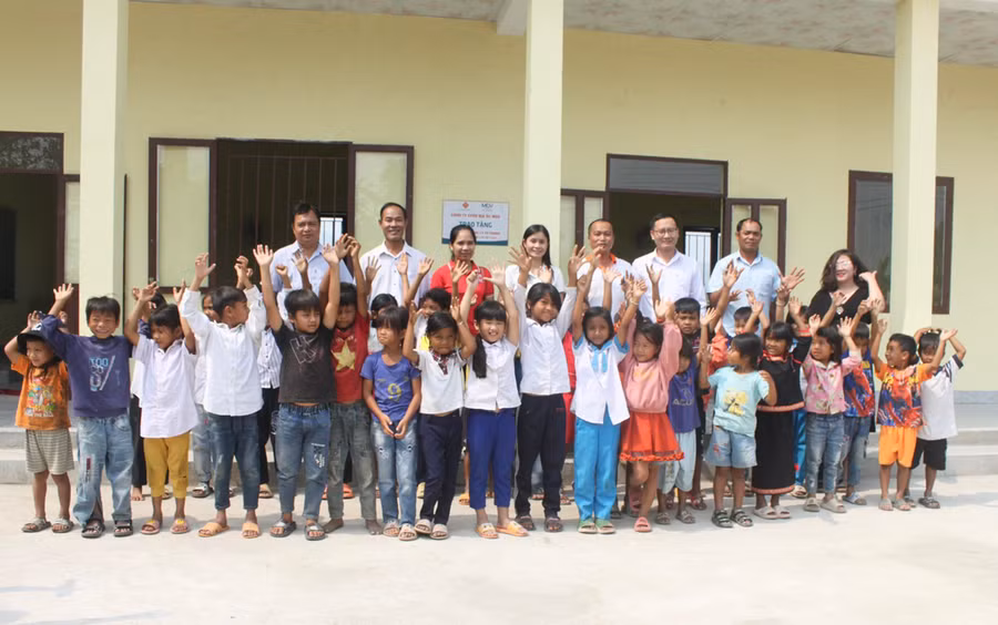 Niềm vui của các em học sinh Trường Tiểu học Lý Tự Trọng (điểm trường thôn Mơ Nai Trang, xã Ia Piar, huyện Phú Thiện) bên dãy phòng học mới được xây dựng từ nguồn xã hội hóa. Ảnh: Vũ Chi