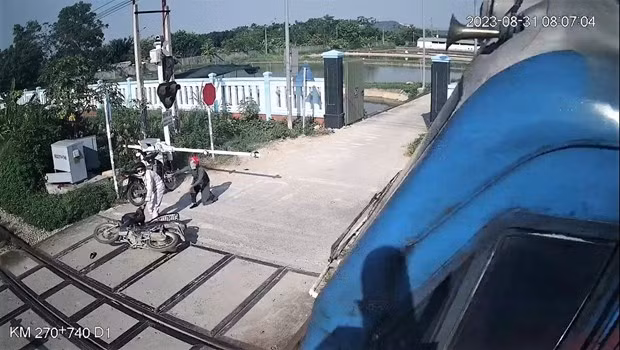 Nữ công nhân thông tin đường sắt Phạm Thị Hường cứu người thoát tai nạn tàu đâm trong gang tấc tại Nghệ An. (Ảnh trích xuất camera giám sát đường ngang).