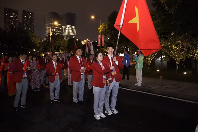 Nguyễn Huy Hoàng và Nguyễn Thị Hường cùng cầm quốc kỳ Việt Nam vào sân