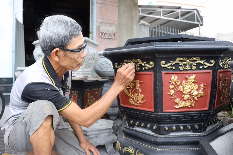 Ông Nguyễn Đức Bình (trú tại số 952 Quang Trung, tổ 1, phường An Phú) tỉ mẩn tô sơn từng họa tiết hoa văn để tăng tính thẩm mỹ, giá trị của chậu cảnh. Ảnh: N.M