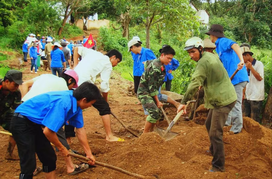 Thanh niên tình nguyện giúp dân làm đường giao thông nông thôn. Ảnh: HL