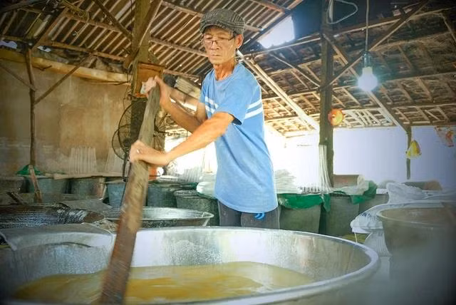 Ông Đồng Văn Chính đang khuấy đường trong chảo. Ảnh: HẢI PHONG