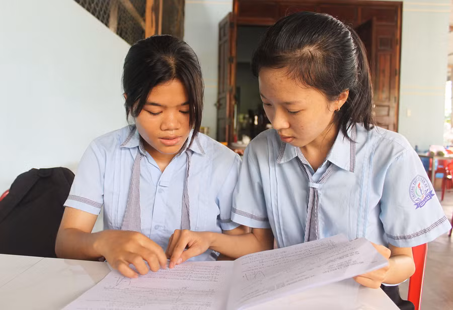 Em Rah Lan H'Hương (bìa trái, học sinh lớp 12A2, Trường THPT Chu Văn An) trao đổi bài với bạn học sau kỳ thi. Ảnh: Vũ Chi