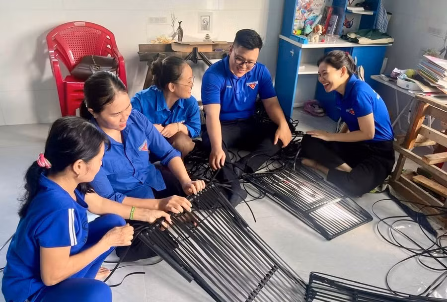 Đoàn viên thanh niên 2 đơn vị nhiệt tình hỗ trợ 1 ngày công đan nhựa giả mây cho chị Hằng. Ảnh: D.L