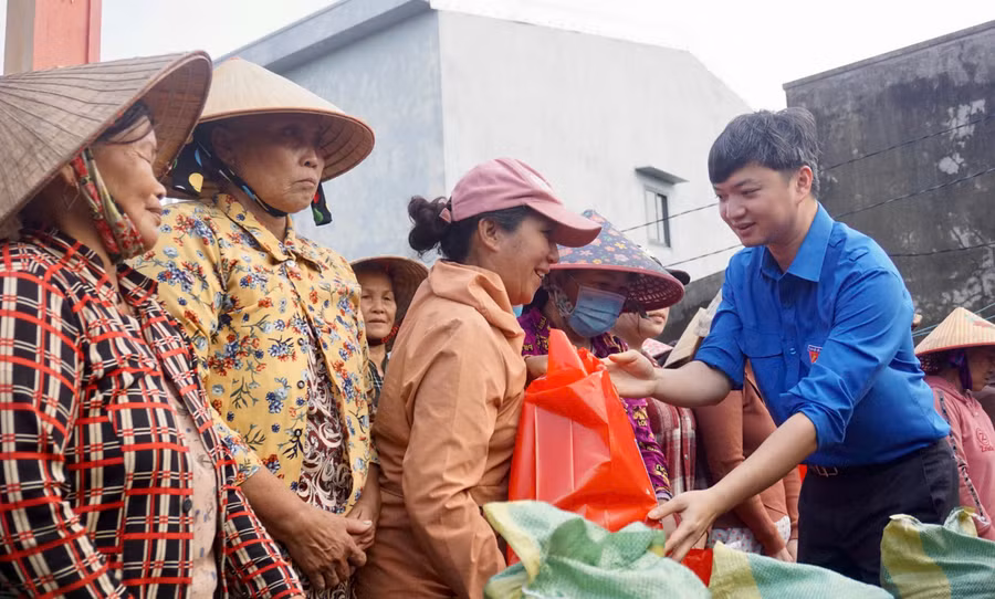 Anh Nguyễn Minh Triết tặng quà cho người dân xóm Cồn Chim. Ảnh: D.L