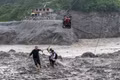 Người dân Nepal dùng cáp treo vượt sông Trishuli sau lũ quét. Ảnh: AP