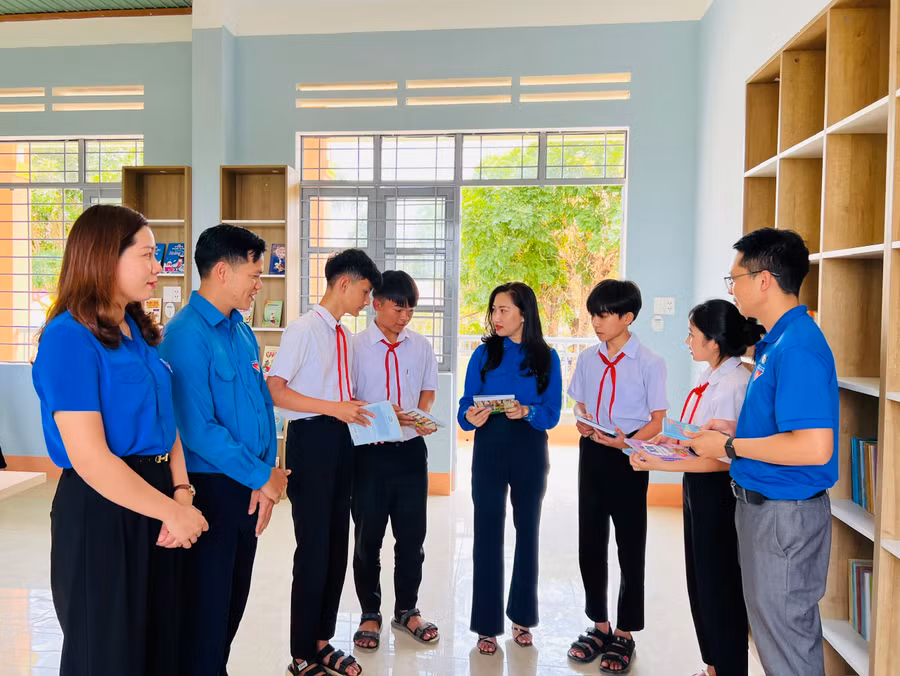 Đại diện Đoàn khối các tỉnh, thành phố và học sinh Trường THCS Nguyễn Đình Chiểu tham quan công trình Thư viện cho em. Ảnh: P.L