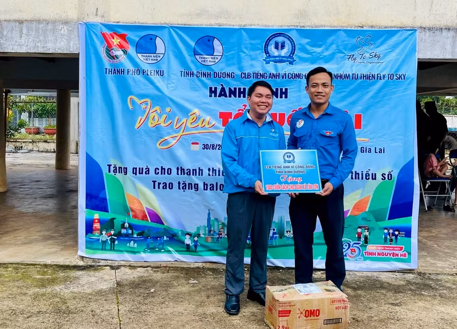 Anh Trương Chấn Sang (bìa trái)-Chủ nhiệm Câu lạc bộ Tiếng Anh vì cộng đồng tỉnh Bình Dương tặng tủ sách cho Đoàn xã Tân Sơn. Ảnh: M.N