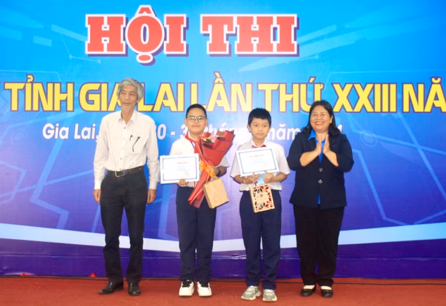 Bí thư Tỉnh Đoàn Hà Thị Giang Thảo (bìa phải) và Giám đốc Sở Thông tin và Truyền thông Nguyễn Ngọc Hùng (bìa trái) trao giải nhất bảng D1 cho nhóm thí sinh. Ảnh: P.L
