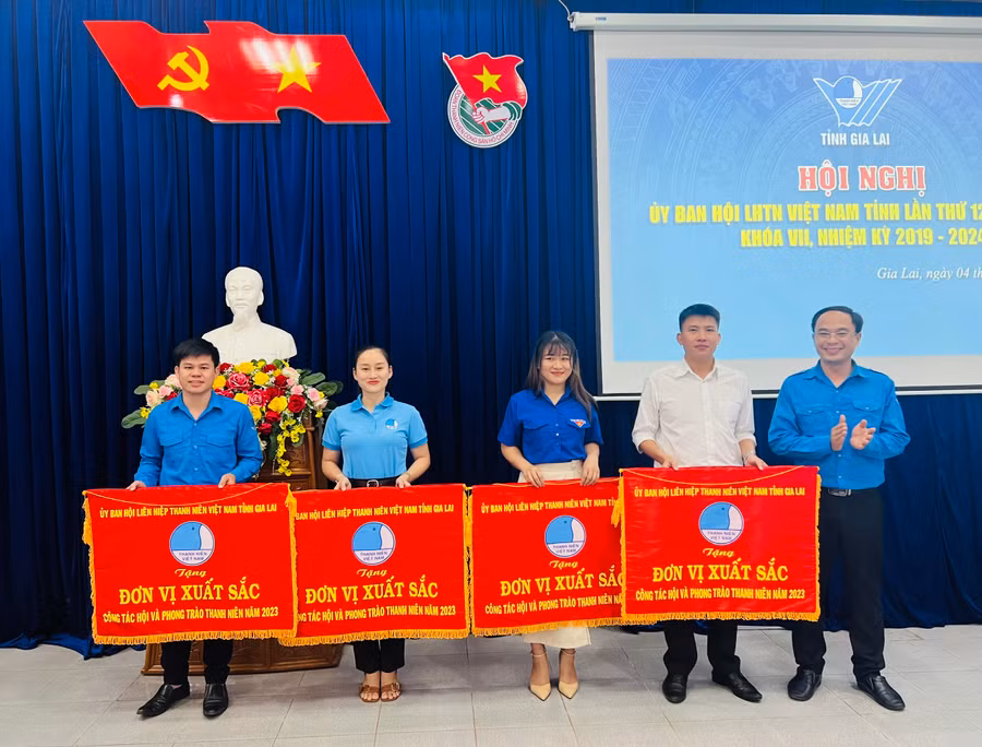 Anh Đỗ Đức Thanh (bìa phải)-Phó Bí thư Tỉnh Đoàn, Chủ tịch Hội LHTN Việt Nam tỉnh trao cờ đơn vị xuất sắc cho các tập thể. Ảnh: P.L