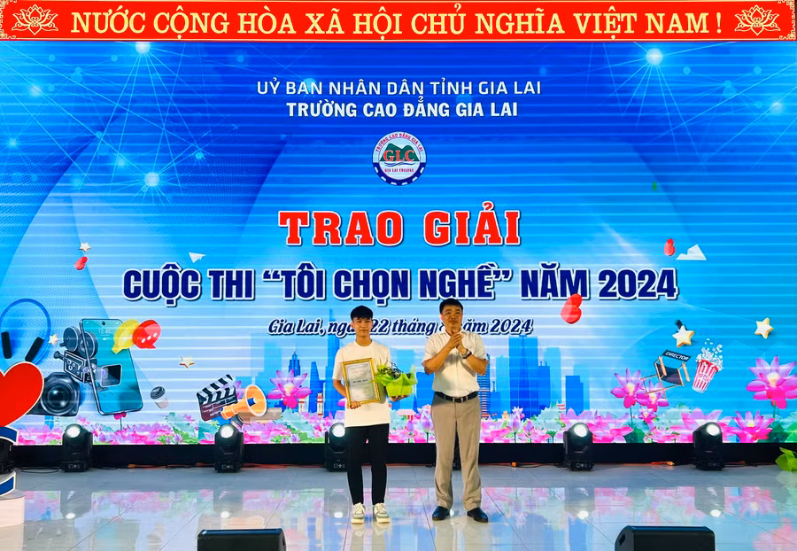 Hiệu trưởng Trường Cao đẳng Gia Lai Phạm Văn Điều (bìa phải) trao giải nhất thể loại video clip của cuộc thi "Tôi chọn nghề" cho sinh viên Phạm Vũ Xuân Hoàng.