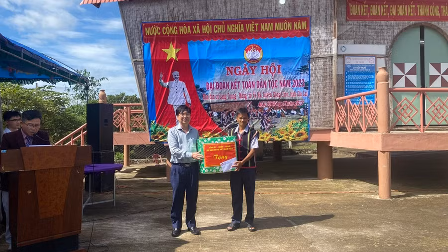 Đồng chí Huỳnh Quang Thái-Trưởng ban Tổ chức Tỉnh ủy trao quà tặng của tỉnh cho bà con làng Tnung- Măng. Ảnh: Sơn Ca