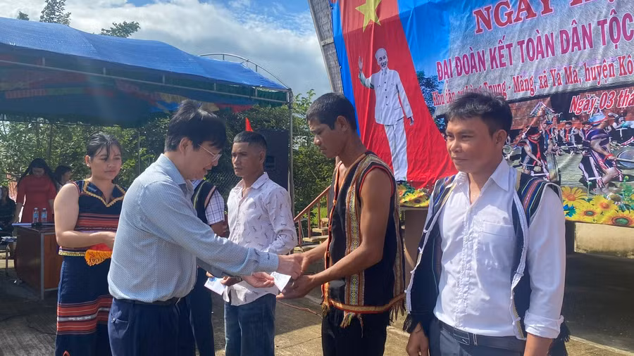 Đồng chí Huỳnh Quang Thái tặng quà cho làng Tnung-Măng và 3 hộ gia đình khó khăn trong làng. Ảnh: Sơn Ca