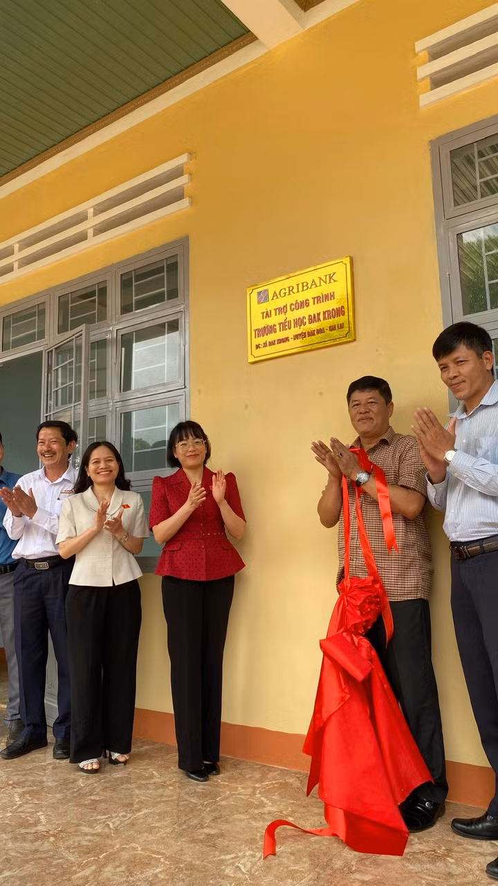 Bà Nguyễn Thị Mai Phương và lãnh đạo huyện Đak Đoa gắn biển công trình tài trợ tại Trường Tiểu học Đak Krong. Ảnh: Sơn Ca.