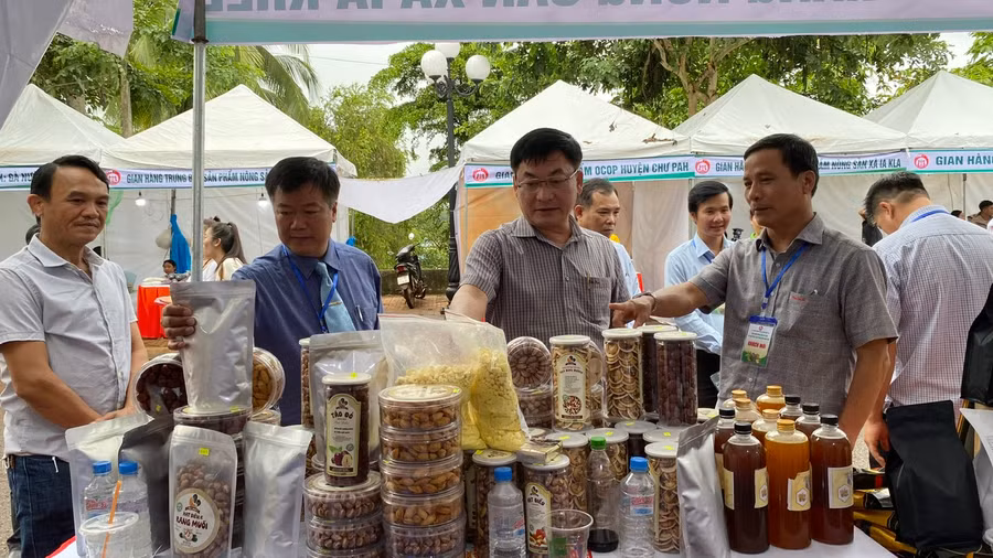 Lãnh đạo UBND huyện Đức Cơ giới thiệu các đại biểu về các sản phẩm nông sản tiêu biểu của địa phương tại chợ phiên. Ảnh: Sơn Ca.