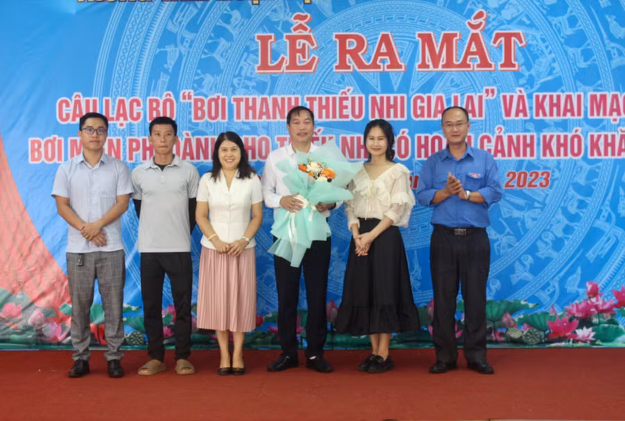 Anh Phan Hồ Giang (bìa phải)-Phó Bí thư Thường trực Tỉnh Đoàn, Giám đốc Trung tâm Hoạt động Thanh thiếu nhi tỉnh Gia Lai trao hoa và quyết định thành lập Câu lạc bộ “Bơi thanh thiếu nhi Gia Lai”. Ảnh: P.L
