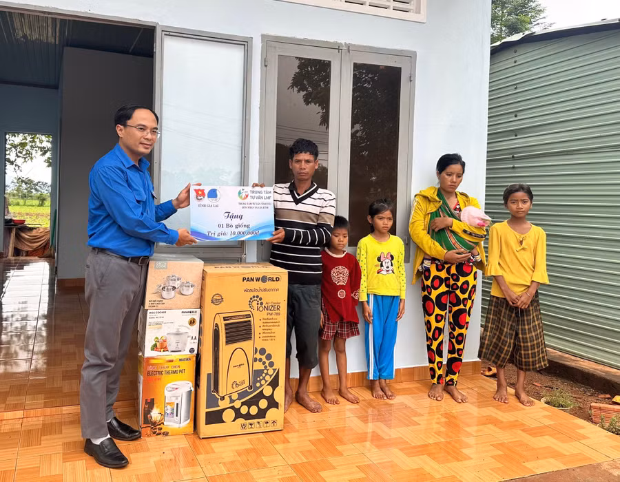 Anh Đỗ Đức Thanh (bìa trái)-Phó Bí thư Tỉnh Đoàn, Phó Chủ tịch Hội LHTN Việt Nam tỉnh trao bảng tượng trưng tặng 1 con bò giống và các vật dụng sinh hoạt cho gia đình chị Rơ Lan H’Mim. Ảnh: Tỉnh Đoàn cung cấp