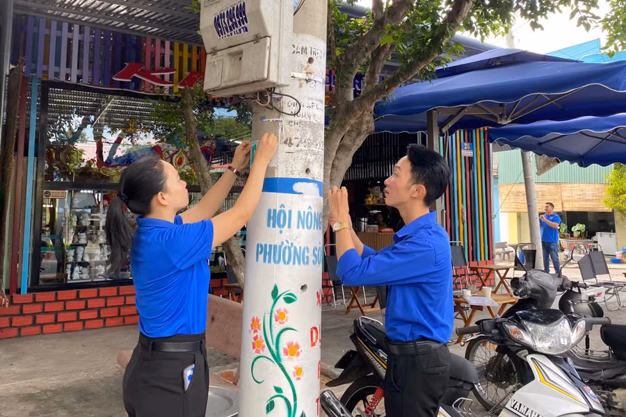 Đoàn viên, thanh niên thị xã Ayun Pa bóc gỡ quảng cáo, rao vặt trên các trụ điện ở phường Sông Bờ. Ảnh: H'Reo