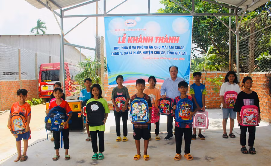 Tiến sĩ Võ Quang Diệm-Chủ tịch Hiệp hội Tấm lợp Việt Nam tặng ba lô và dụng cụ học tập cho các em nhỏ Mái ấm Giuse. Ảnh: P.L