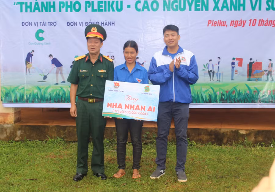 Đại diện Thành Đoàn Pleiku và Sư đoàn 320 trao bảng tượng trưng nhà nhân ái cho chị Siu Suên (ở giữa)-Bí thư Chi đoàn làng A (xã Gào). Ảnh P.L