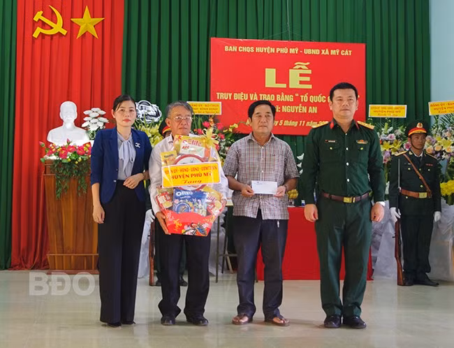 Bộ CHQS tỉnh và lãnh đạo UBND huyện Phù Mỹ tặng quà cho thân nhân gia đình Liệt sĩ. Ảnh: Thành Phúc
