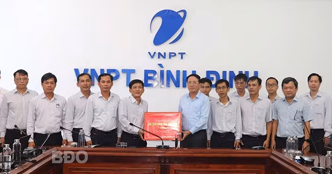 Chủ tịch UBND tỉnh Phạm Anh Tuấn (hàng trên, thứ 4 từ phải sang) tặng quà động viên cán bộ, nhân viên VNPT Bình Định. Ảnh: M.H