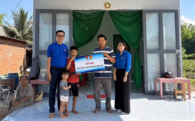 Lãnh đạo huyện Đoàn - Hội đồng Đội Phù Cát trao kinh phí hỗ trợ xây nhà cho gia đình em Nguyễn Nhật Tân. Ảnh: Trường Giang.