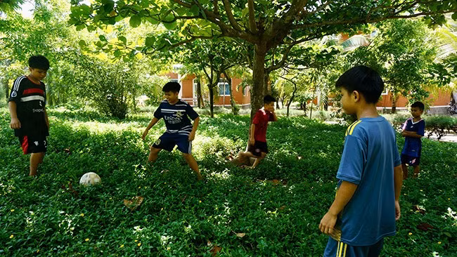 Các bé trai chơi trò chuyền bóng sau khi phụ mẹ việc nhà. Ảnh: T.K Các bé trai chơi trò chuyền bóng sau khi phụ mẹ việc nhà. Ảnh: T.K